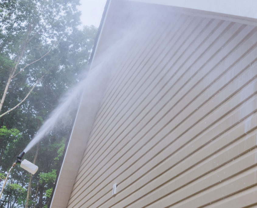 Side view of the side of a house being power washed